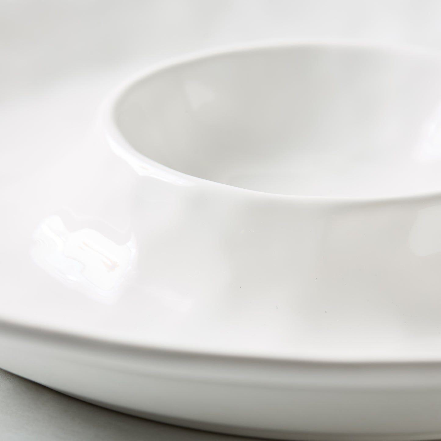 White ceramic 15"Dia chip and dip serving platter with a European-inspired design.