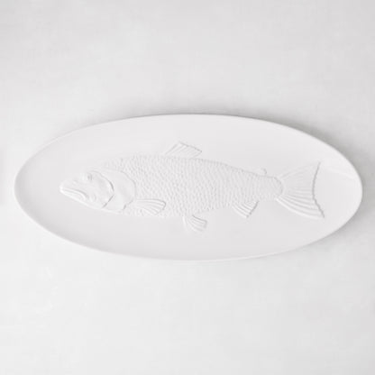 White ceramic oval serving platter with an embossed fish design.