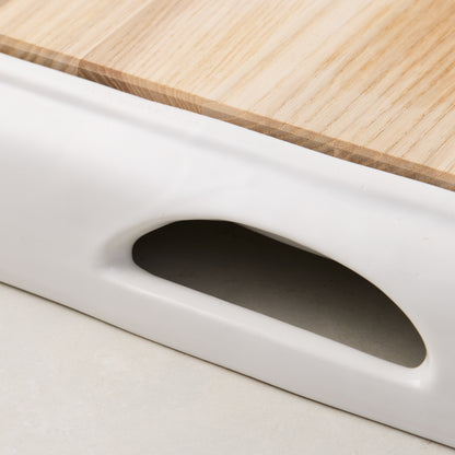 White ceramic handled cutting board with light oak wood surface.