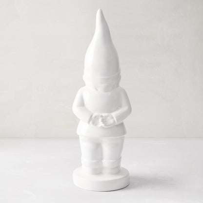 White ceramic holiday gnome with a tall, pointed hat and creamy white glaze.