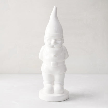 White ceramic holiday gnome with a tall, pointed hat and creamy white glaze.