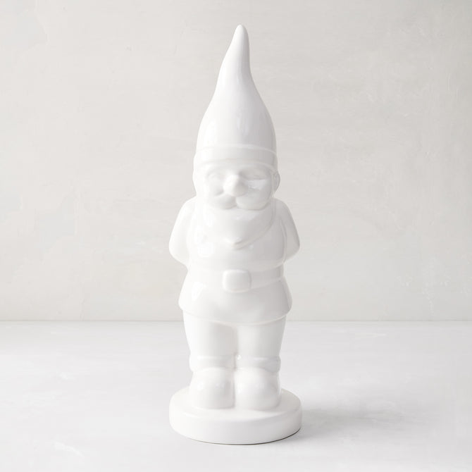 White ceramic holiday gnome with a tall, pointed hat and creamy white glaze.