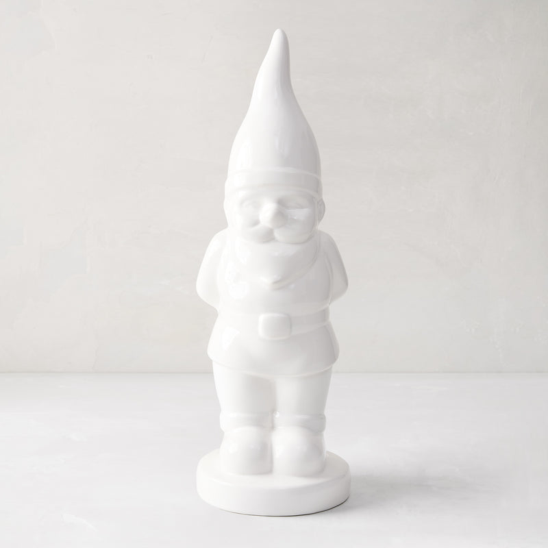 White ceramic holiday gnome with a tall, pointed hat and creamy white glaze.