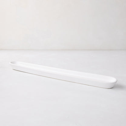 White ceramic olive serving tray, 16" long, with a narrow, rectangular shape and rounded ends.