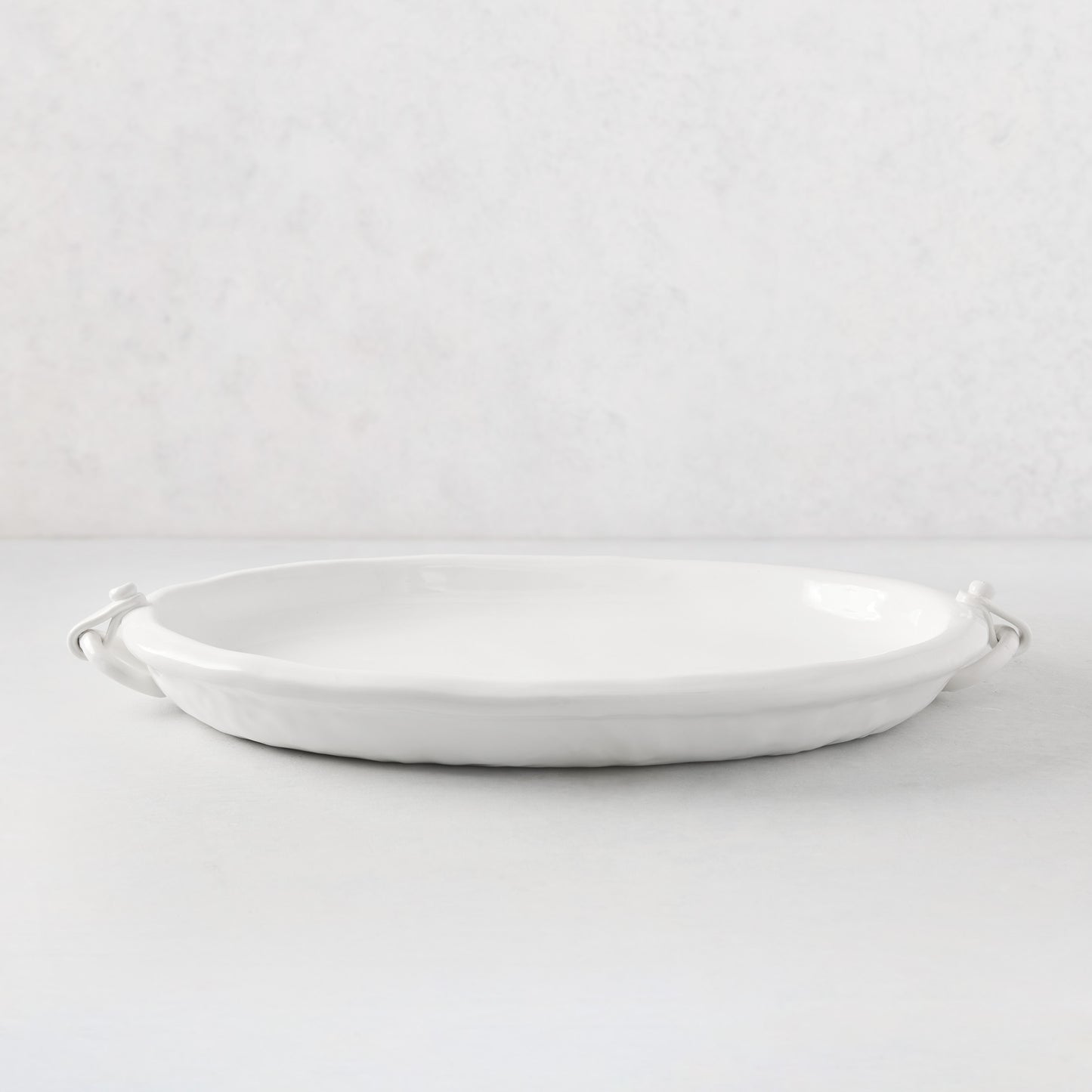 White ceramic oval platter with faux strap ring handles, 22.5"L.