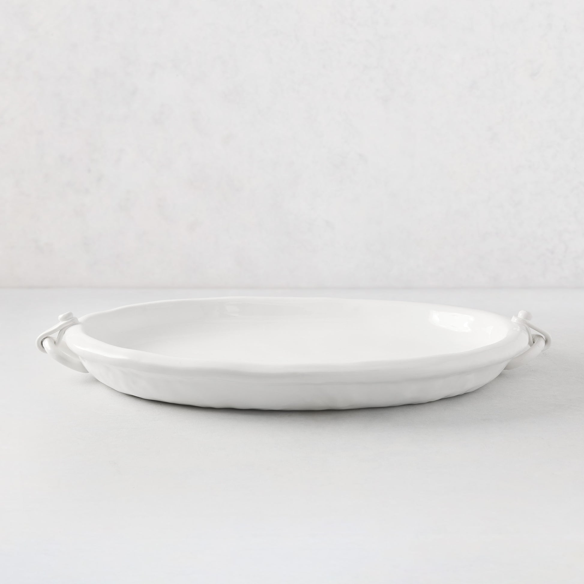 White ceramic oval platter with faux strap ring handles, 22.5"L.