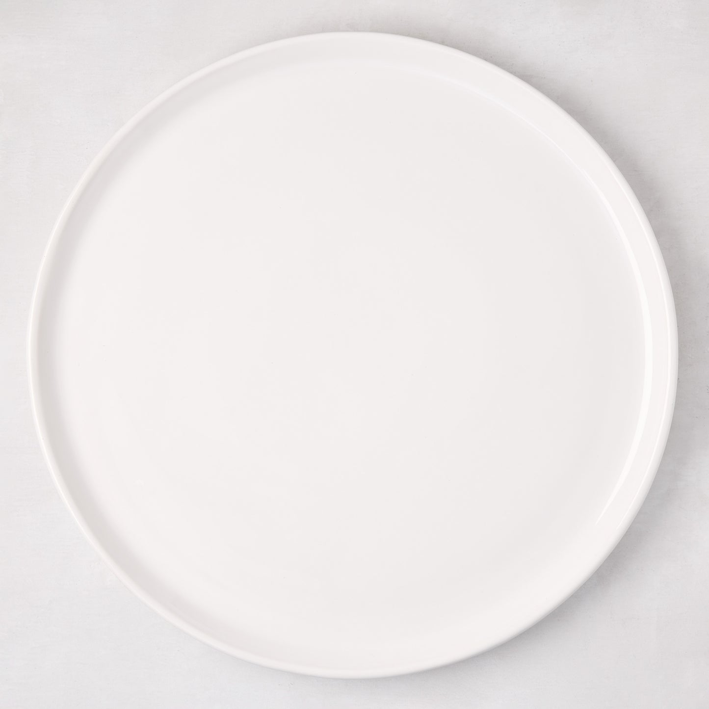 White ceramic round pizza serving platter, 12.6-inch diameter, with a subtle raised edge.