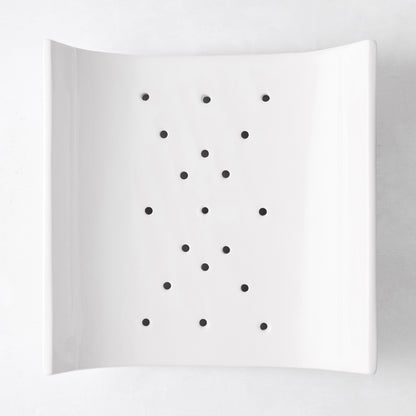White ceramic vegetable drainer, square with rounded corners, open-ended design, small drainage holes.
