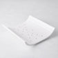 White ceramic vegetable drainer with an open-ended, curved design and drainage holes.