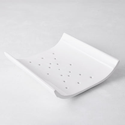 White ceramic vegetable drainer with an open-ended, curved design and drainage holes.
