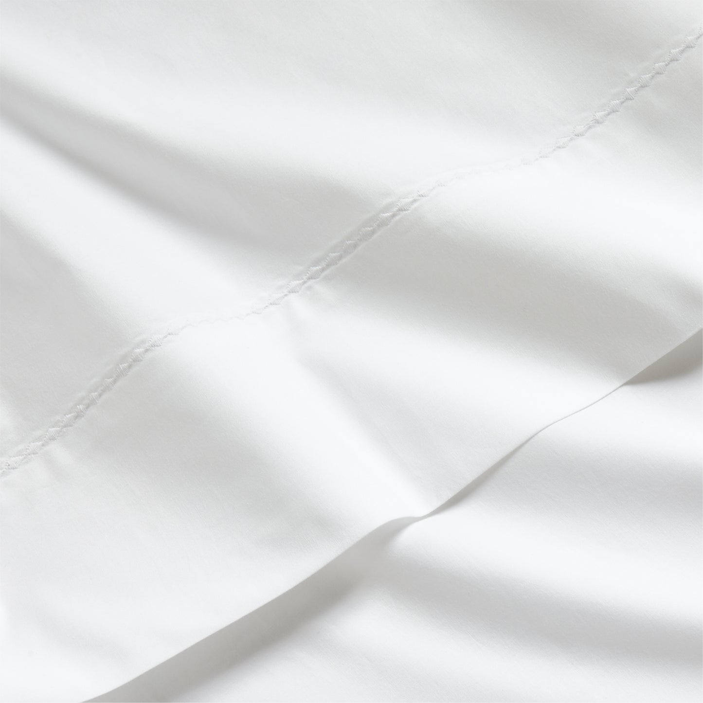 White Diamond Percale Sheet Set, crisp white extra-long staple cotton with subtle diamond embroidery.