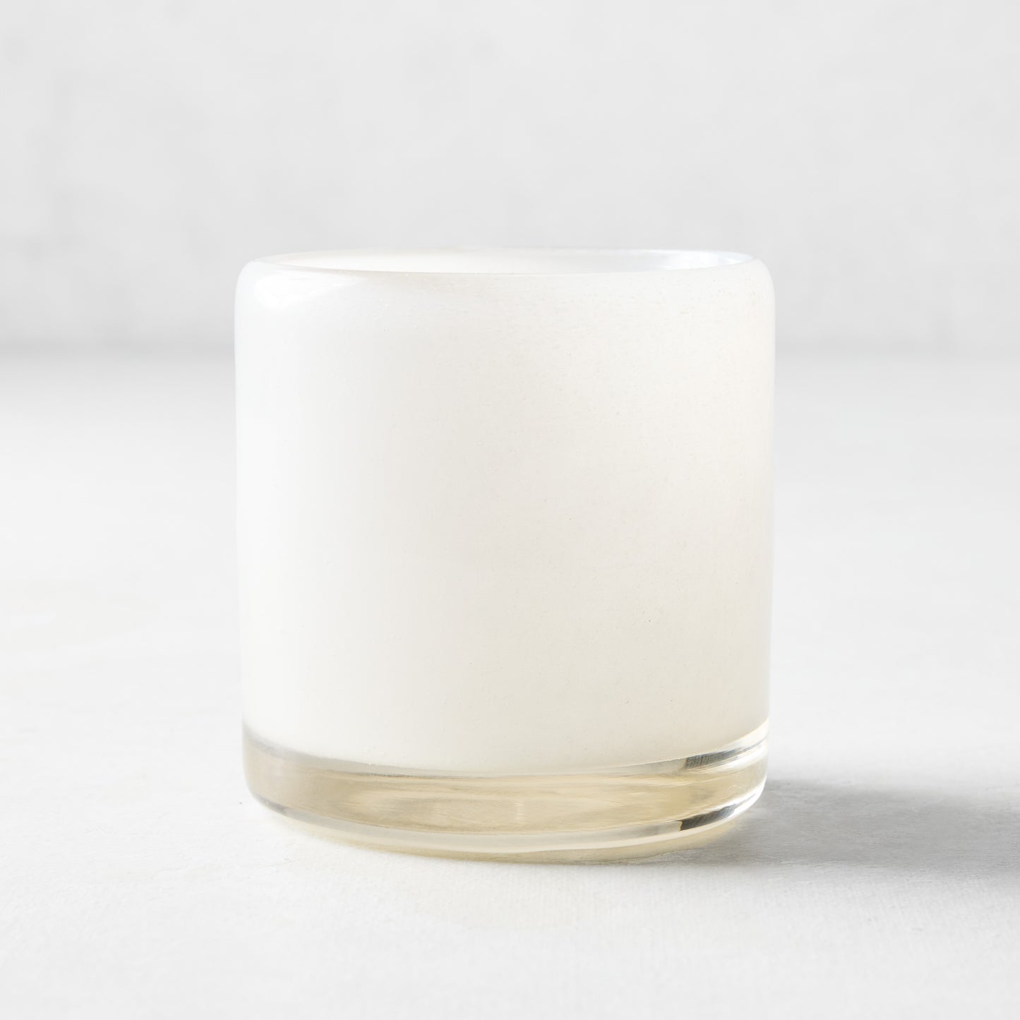 Small white glass votive candle holder, 2.75"Dia x 2.75"H, with a clear base.