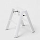 Hudson Grace white Hasegawa Lucano 2-step ladder with a minimalist aluminum and steel design and non-skid feet.