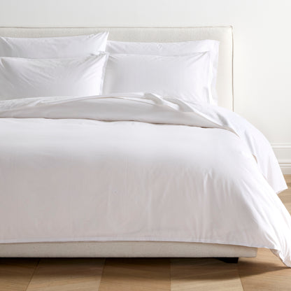 White Italian Percale Duvet Set with duvet cover and two shams on a bed.