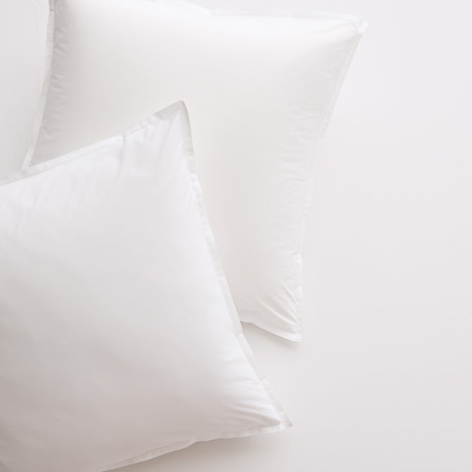 Two white Italian percale Euro shams, crisp cotton fabric with envelope closures, on a light background.