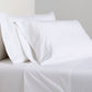 White Italian Percale Sheet Set with two pillowcases and flat sheet on a bed.