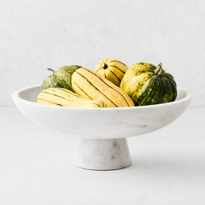 White marble footed serve bowl, 12"Dia x 4.75"H, filled with striped green and yellow gourds.