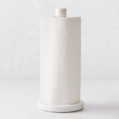 White marble paper towel holder with a heavy round base and sleek pole, holding a roll of white paper towels.