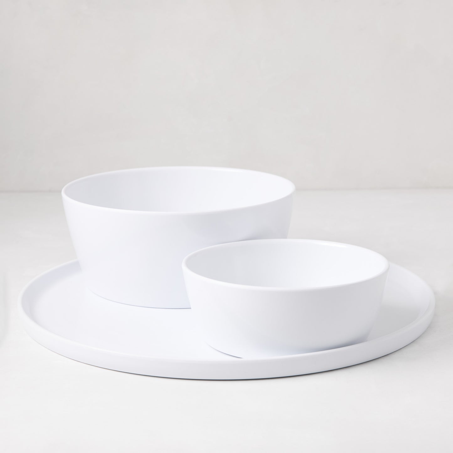 HG White Melamine Serve Bowl, 9"Dia x 3.78"H, with a smaller bowl and plate, on a white surface.