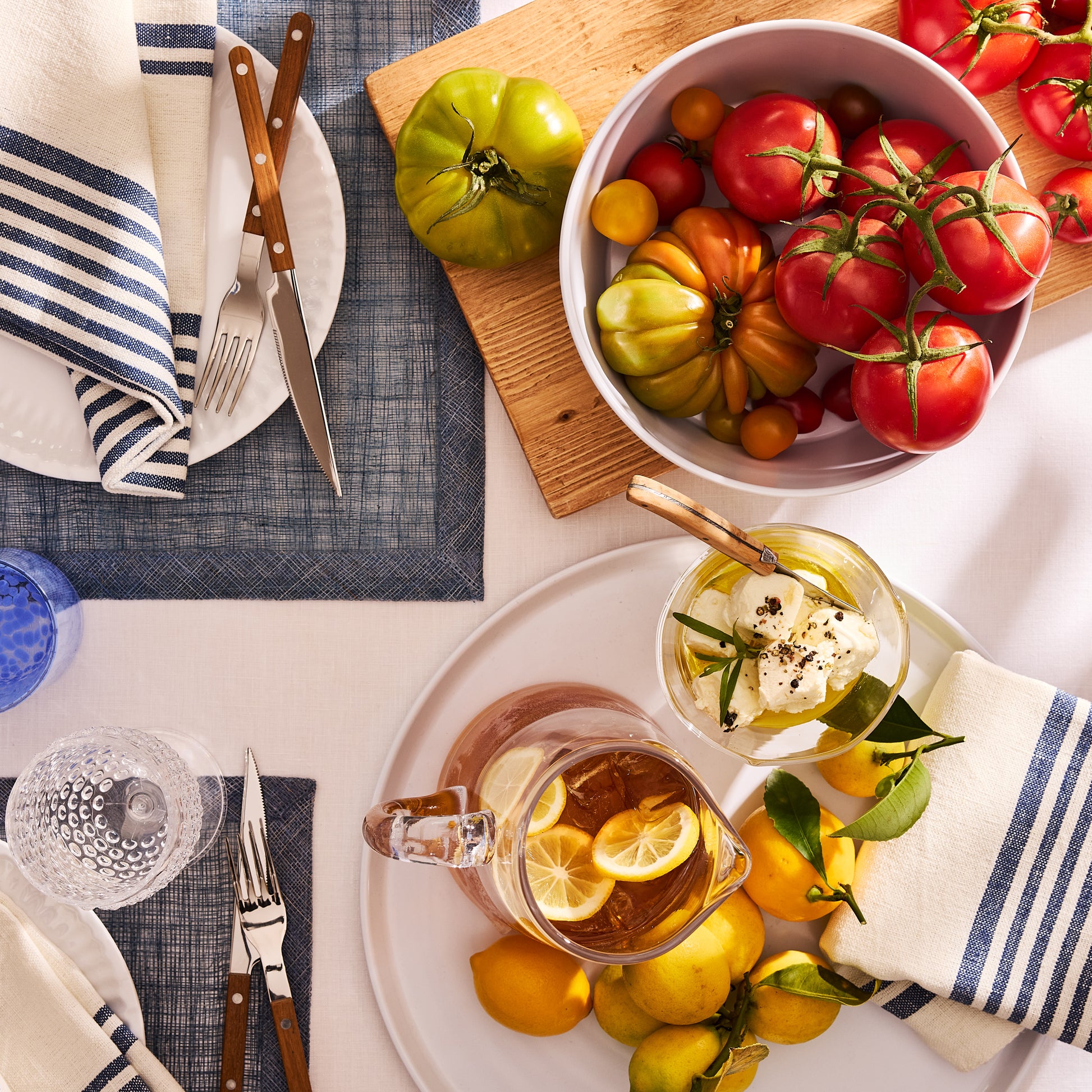 White melamine serve bowl with a modern lipped design, filled with colorful heirloom tomatoes.