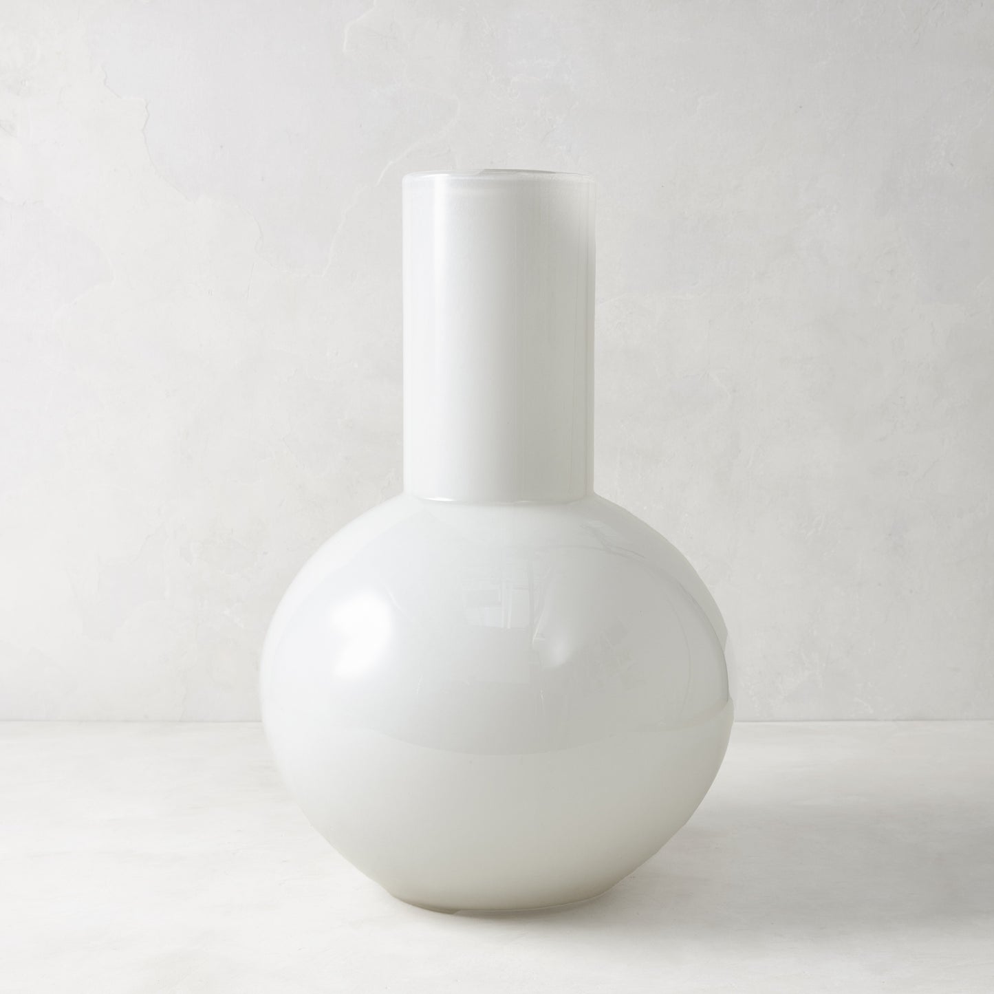 White oversized opaque glass Grando vase with a round base and cylindrical neck.