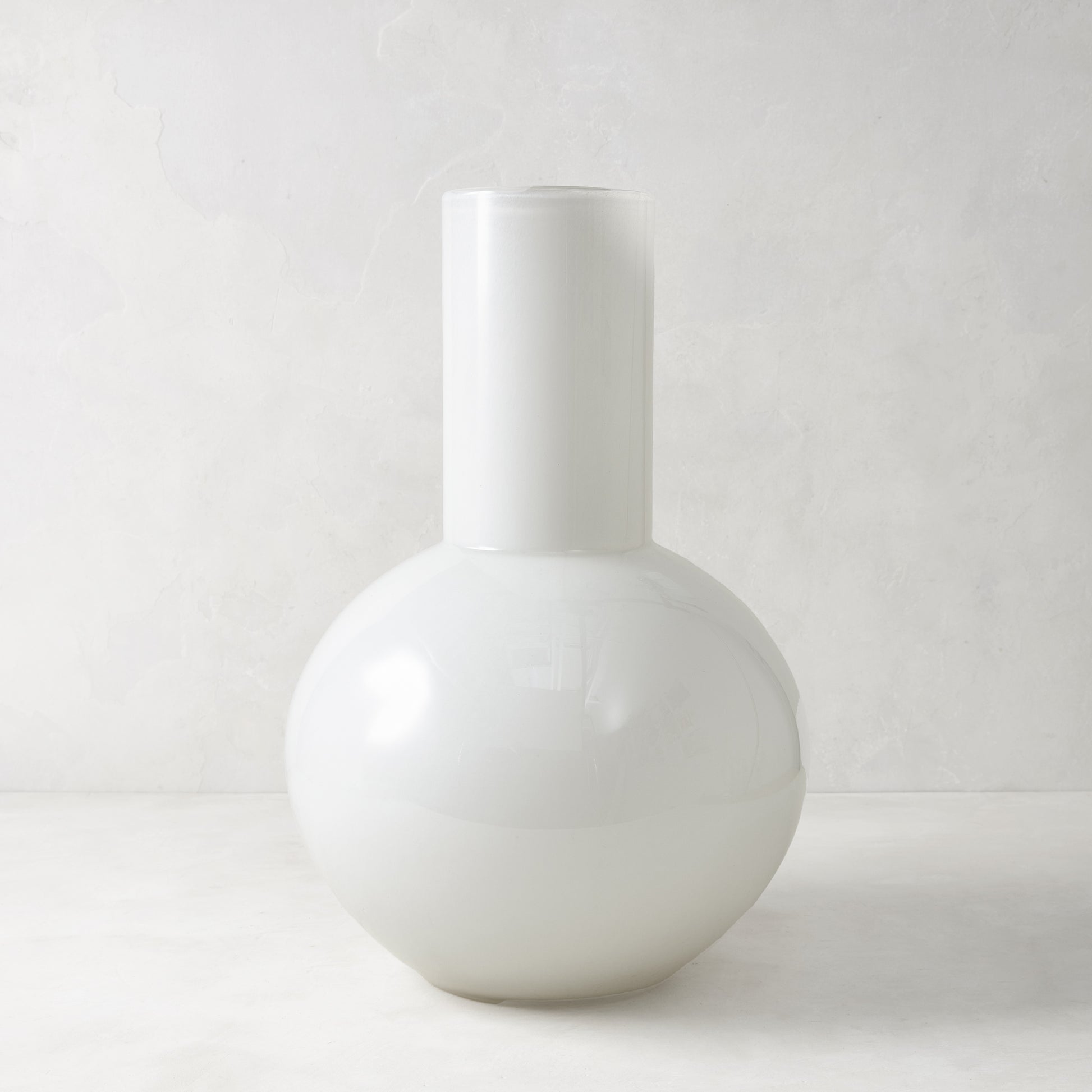 White oversized opaque glass Grando vase with a round base and cylindrical neck.