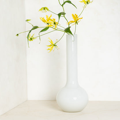 White oversized Raymond glass vase, handblown, with yellow flowers, 9.9”W x 23.6”H.