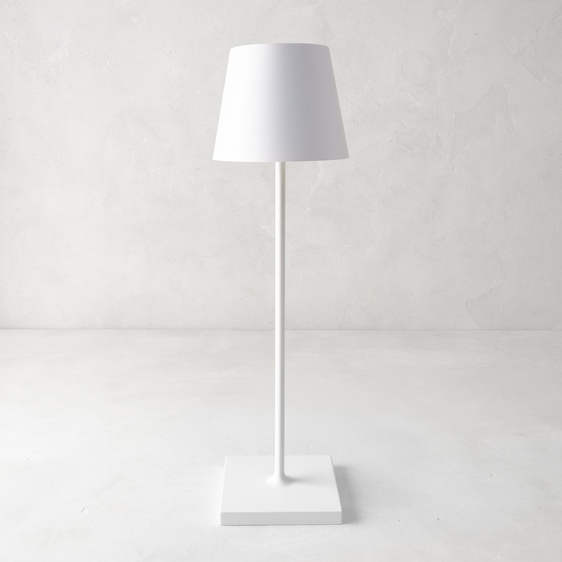 White Poldina indoor/outdoor rechargeable lamp with a sleek, minimalistic design and square base.