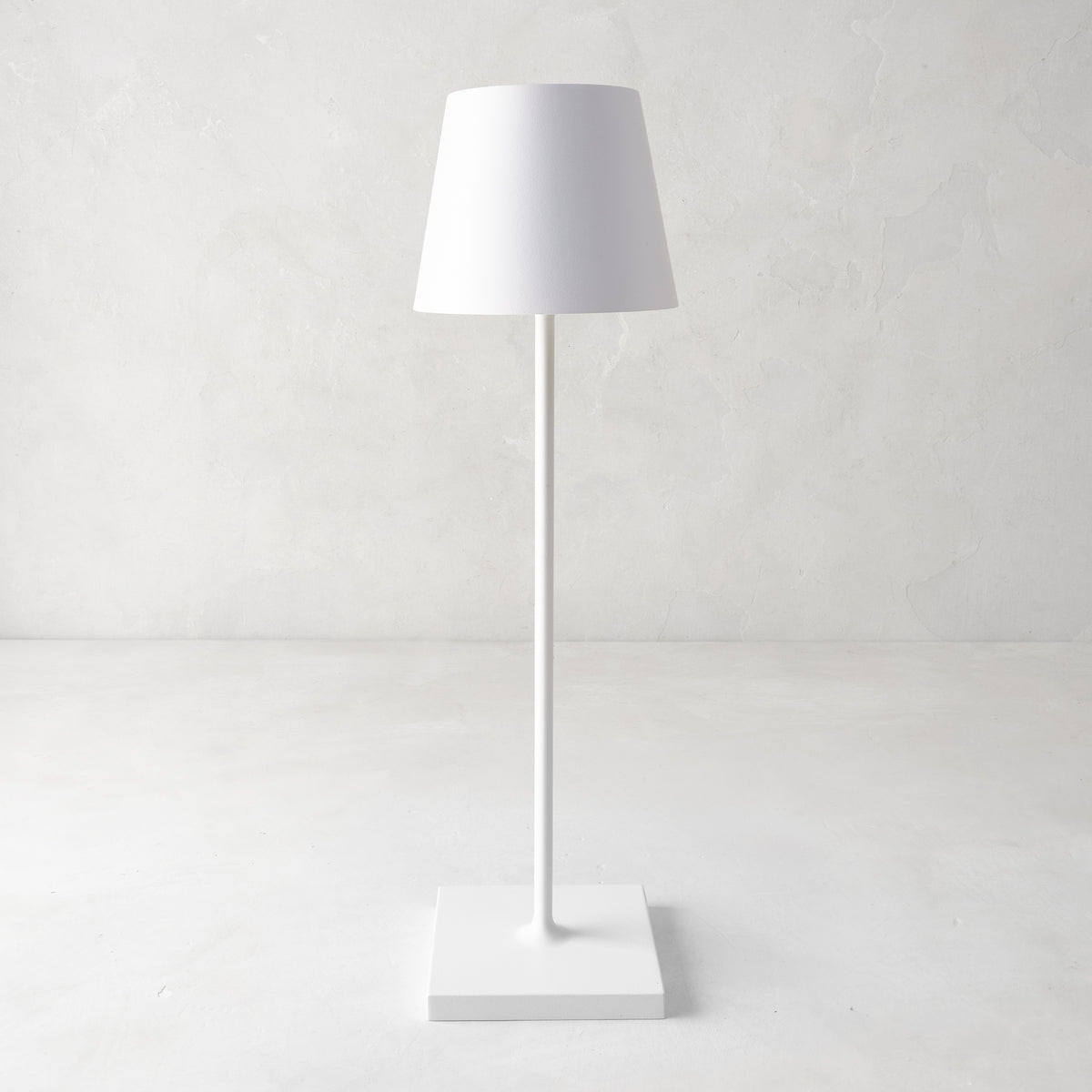 White Poldina indoor/outdoor rechargeable lamp with a sleek, minimalistic design and square base.