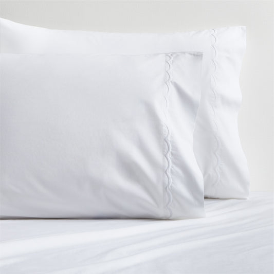 Set of 2 white percale pillowcases with delicate scallop stitch trim.