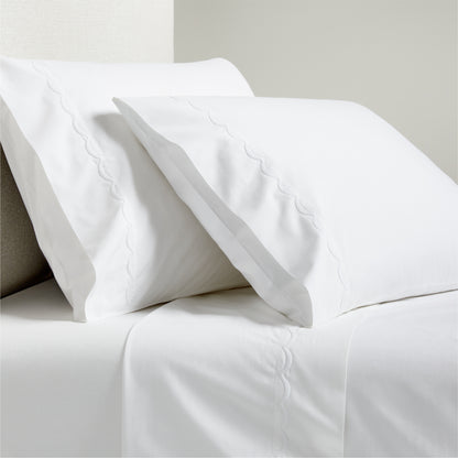 White percale sheet set with scallop stitch embroidery on pillowcases and flat sheet.