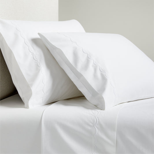 White percale sheet set with scallop stitch embroidery on pillowcases and flat sheet.