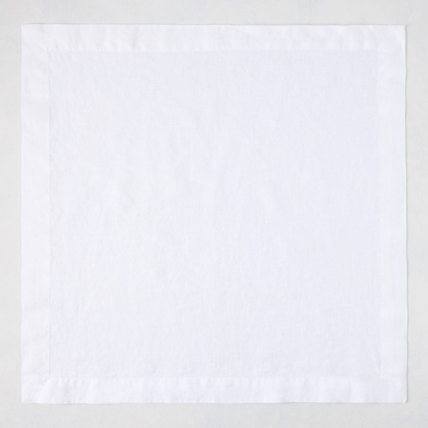 White HG Signature hand-dyed 22-inch square linen napkin with mitered corners.