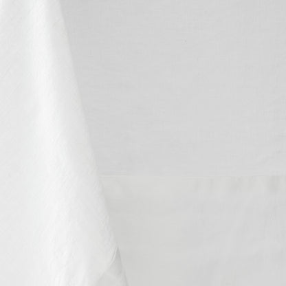 White hand-dyed 100% linen tablecloth with a soft texture and mitered corner detail.