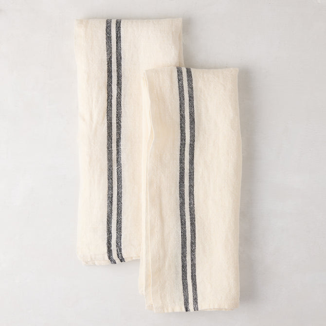 Set of 2 white French linen hand towels with black stripes, folded on a light surface.