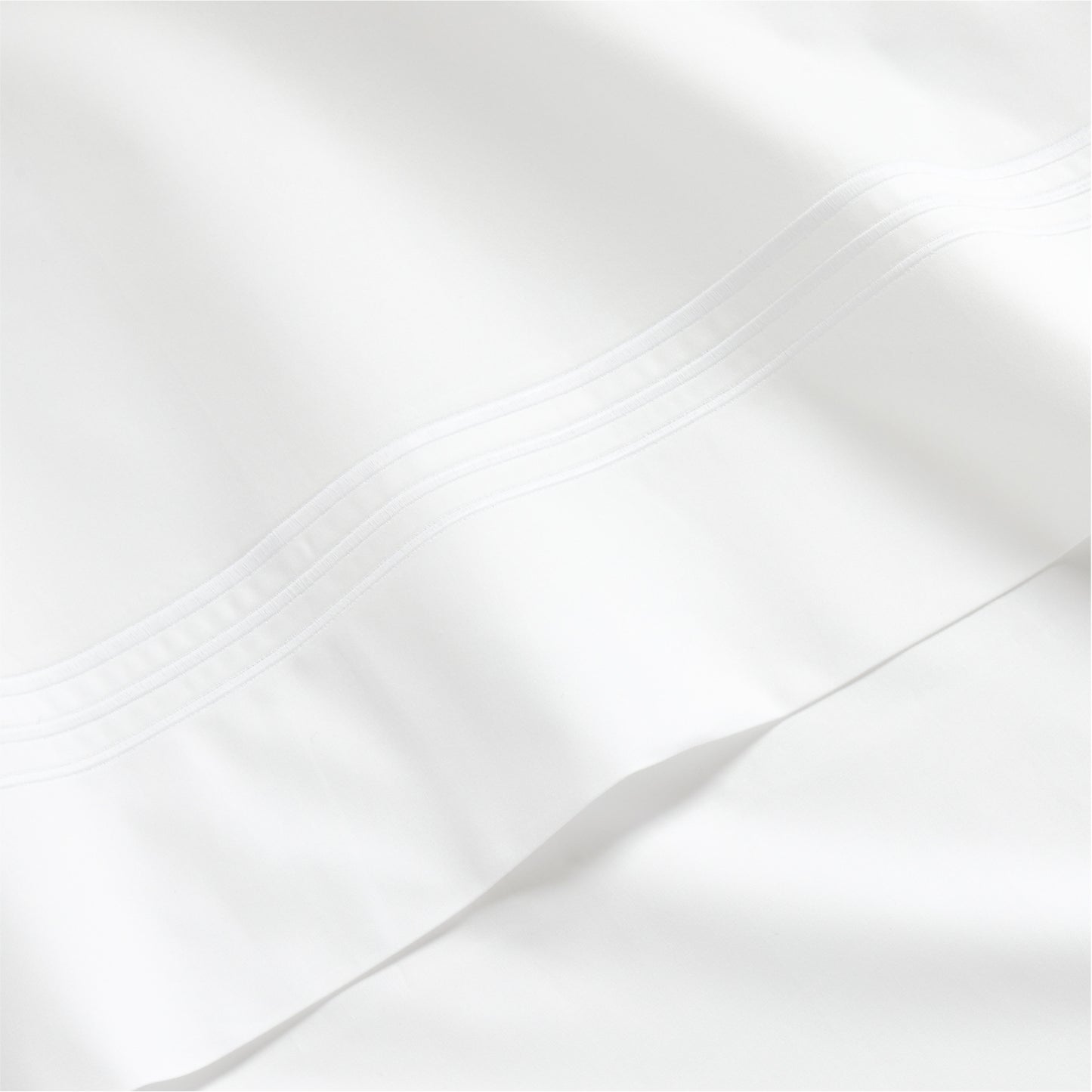 White percale sheet set with a thin triple stitch detail on the hem.