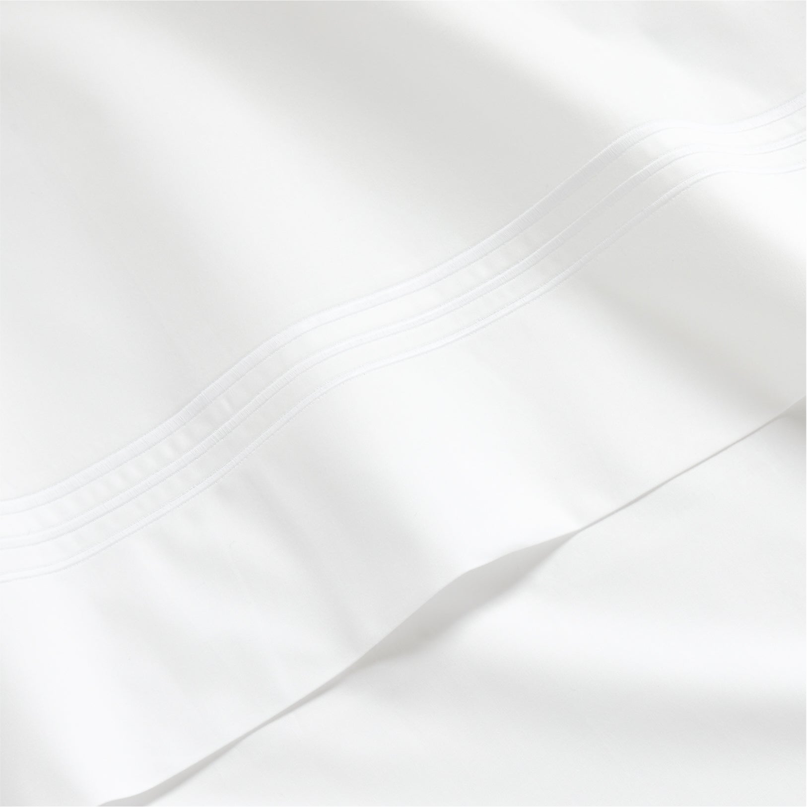 White percale sheet set with a thin triple stitch detail on the hem.