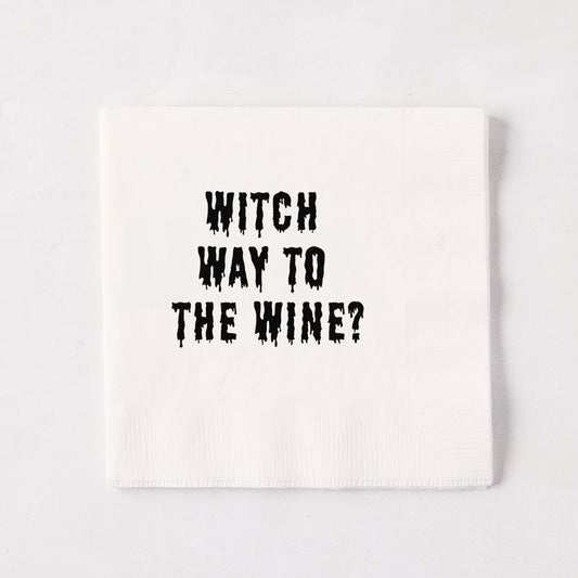 White 5.5-inch square 3-ply paper cocktail napkin with black dripping text reading Witch Way to the Wine.