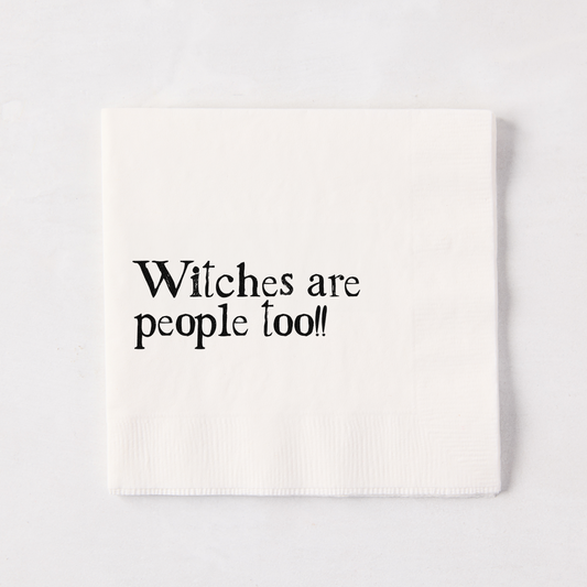 White 5.5" square paper napkin with "Witches are people too!!" in black text.