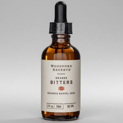 Woodford Reserve Orange Bitters in a small amber glass bottle with a black dropper cap and cream label.