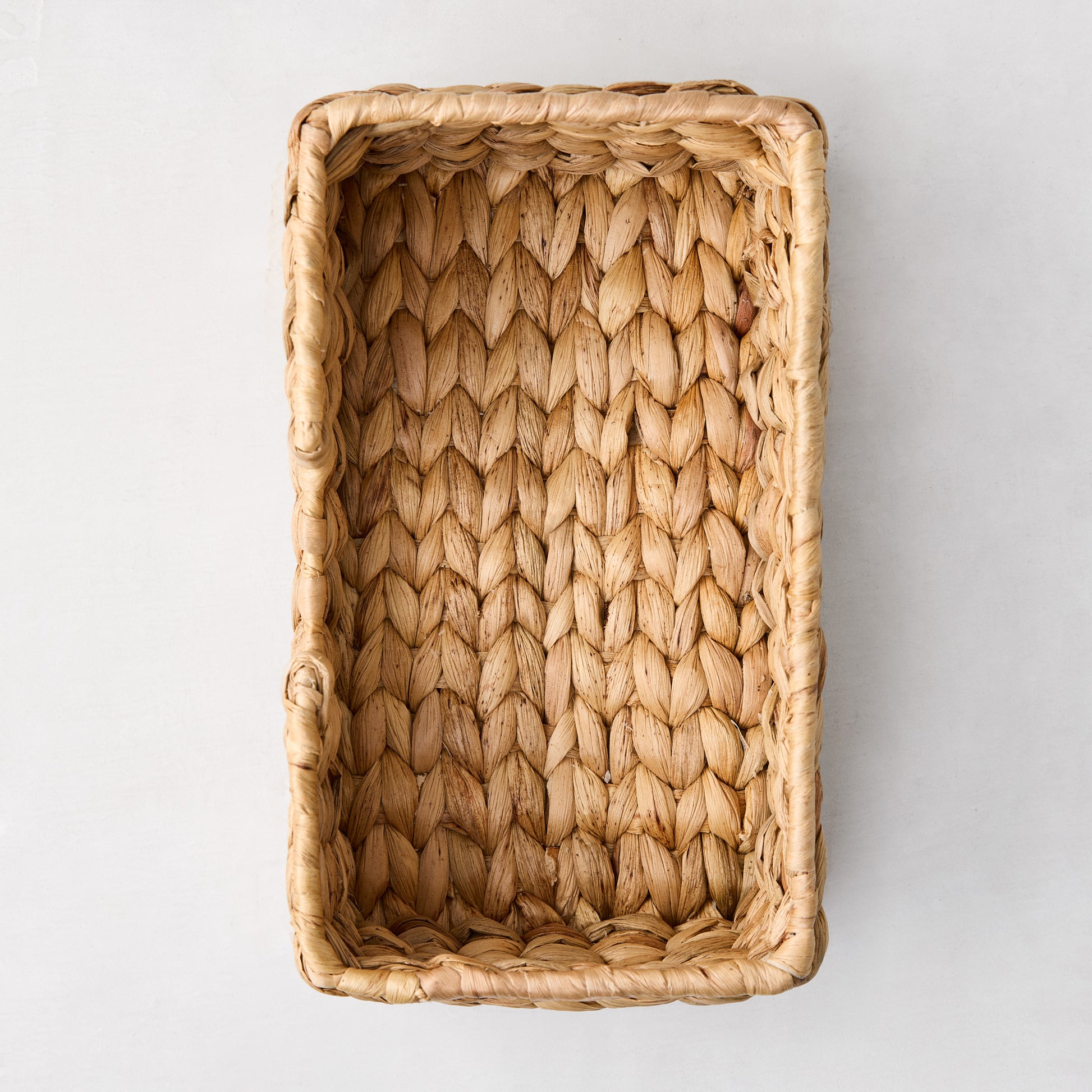 Woven hyacinth hand towel holder, rectangular, natural light brown, tightly woven texture.