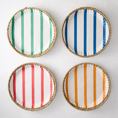 Set of 4 round woven seagrass plates with colorful striped paper liners: green, blue, red, and orange.