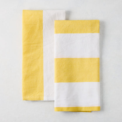 Set of 2 yellow and white block print cotton-linen hand towels; one striped, one half yellow/half white.