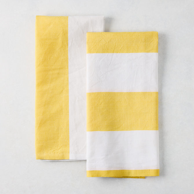 Set of 2 yellow and white block print cotton-linen hand towels; one striped, one half yellow/half white.