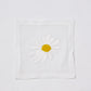 White linen 6" square coaster with hand-embroidered white and yellow daisy.