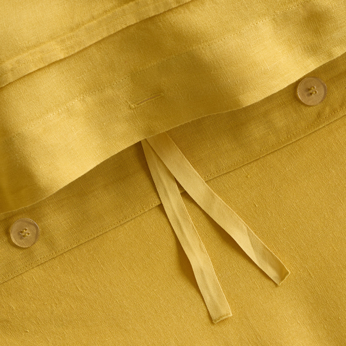 Yellow European washed linen duvet cover with button closures and fabric ties.