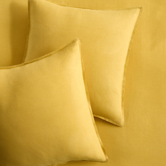 Set of two square yellow European washed linen euro shams with a simple flange edge.