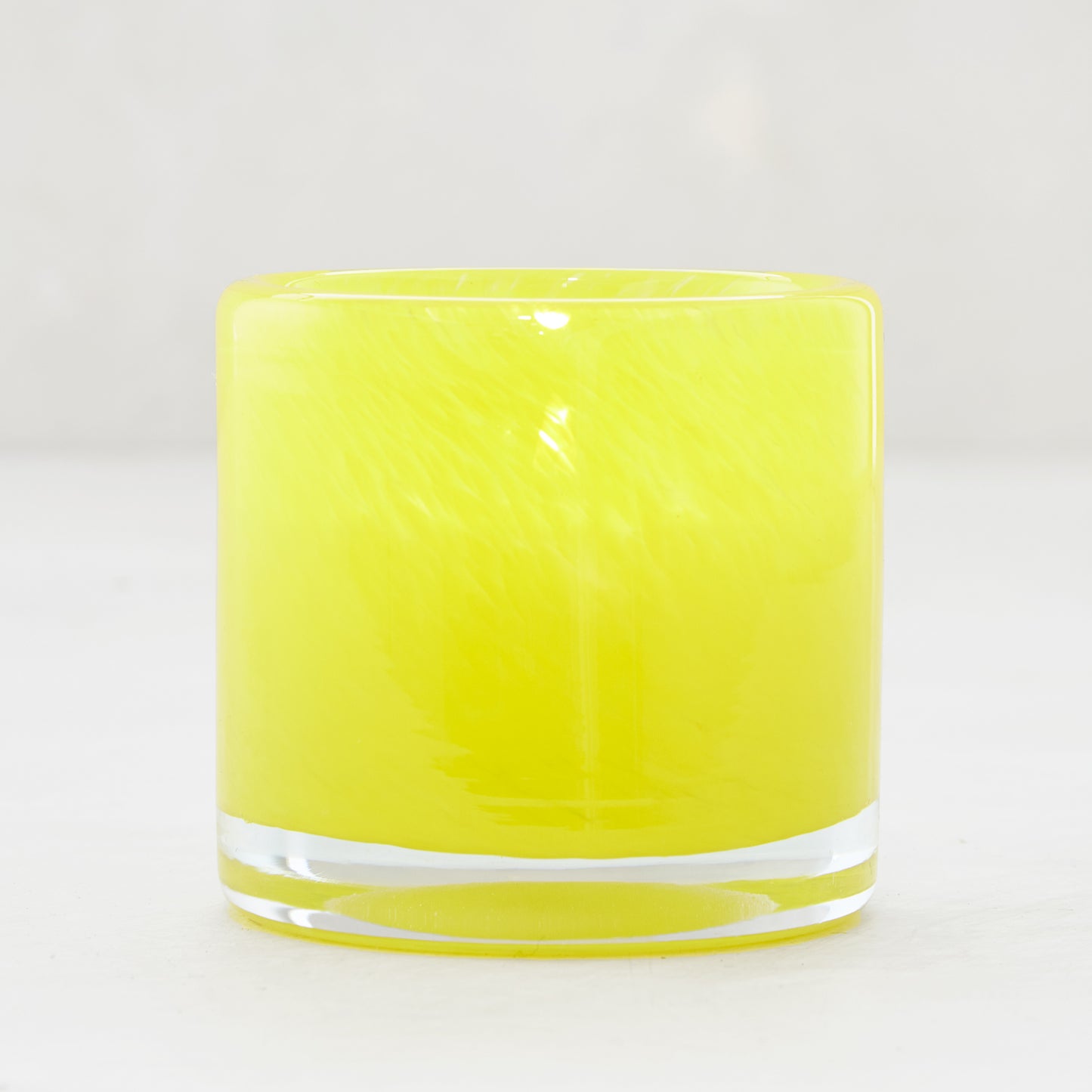 Bright yellow glass votive candle holder, 2.75" tall, with a clear base.