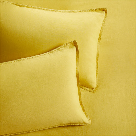 Set of 2 yellow washed Italian linen pillow shams with 2" flange and double-needle stitching.