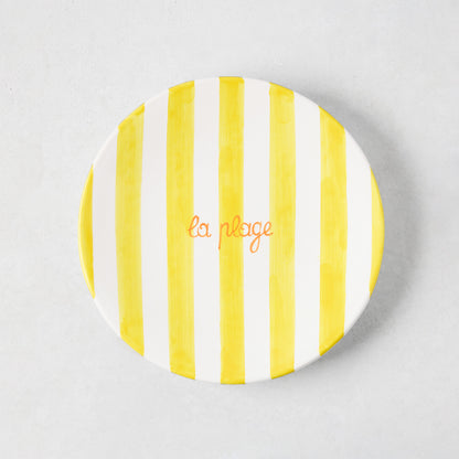 Hand-painted ceramic appetizer plate with bright yellow stripes and orange "la plage" text.